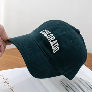 Close-up of white Colorado 3D embroidery on deep green textured baseball cap
