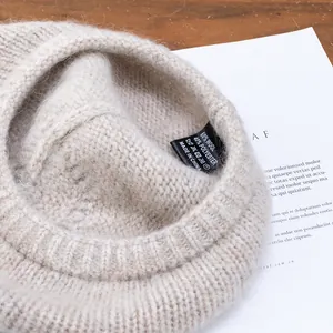 Beige mohair knit beret with 60% wool blend shown with detailed washing label texture