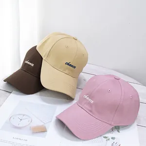 Detalle de tres gorras de béisbol de algodón con bordado en tonos neutros suaves