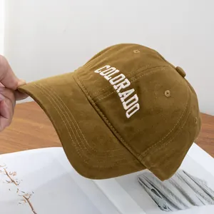 Detail of dark brown cotton baseball cap featuring white Colorado embroidery on front