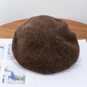 Close-up of fuzzy brown mohair knit beret showing plush texture on wooden table