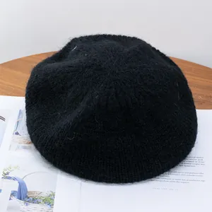 Close-up of black mohair knit beret showing fluffy wool texture and thick plush weave