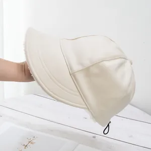 Dettaglio del cappello in peluche bianco panna con coulisse regolabile e fodera calda
