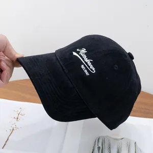 Detail shot of black brushed cotton baseball cap with white Mioobean letter embroidery