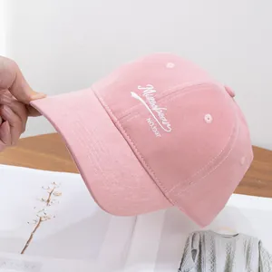 Close-up of pink corduroy baseball cap with Mixobear embroidery and soft texture