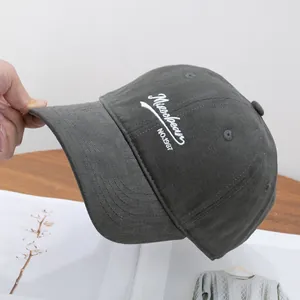 Detail of dark grey cotton baseball cap with white Missbeans embroidery and sturdy brim