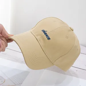 Bordado detallado de letras azules chance en la parte delantera de una gorra de algodón beige