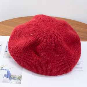 Macro detail of red mohair knit beret showing soft fluffy texture and woven pattern