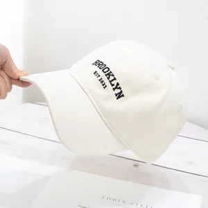 Detailed close-up of retro Brooklyn 1634 embroidery on cream cotton baseball cap