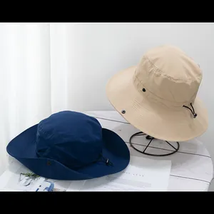 Detail of outdoor wide-brim sun hat with adjustable chin strap and side press buttons