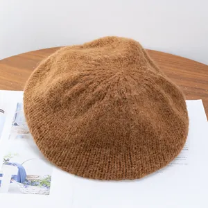 Detail of soft mohair knit beret in brown caramel texture on a wooden table
