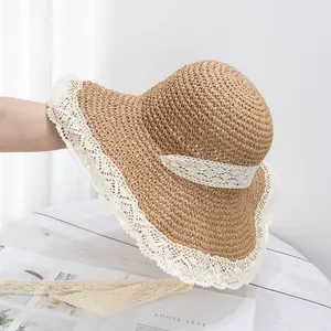 Détail du chapeau de soleil en paille à large bord avec bordure en dentelle et rubans noués