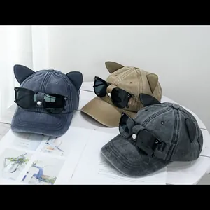 Trois casquettes de baseball oreilles de chat avec lunettes pilote sur table blanche