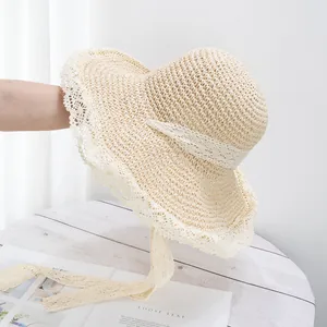 Gros plan détaillé d'un chapeau de paille crème avec tissage évidé et bord en dentelle