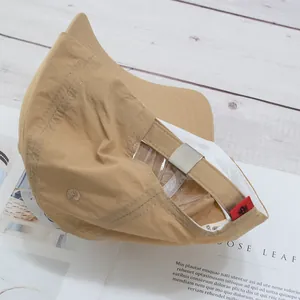 Detail view of khaki baseball cap with metallic adjustable buckle and red side label