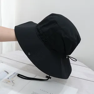 Detail of black quick-dry sun hat with adjustable drawstring and metal side buttons