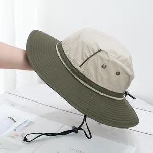 Detail of wide-brim sun hat showing breathable metal eyelets and adjustable wind rope