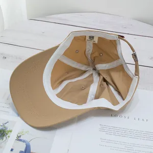 Light khaki thin baseball cap showing interior lining, sweatband and metal buckle detail