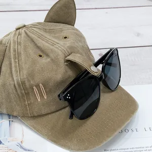 Détail de la casquette kaki à oreilles de chat avec lunettes aviateur noires intégrées