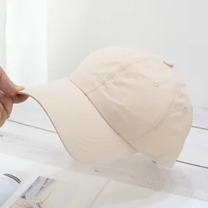 Macro view of lightweight beige baseball cap showing white stitching and quick-dry fabric