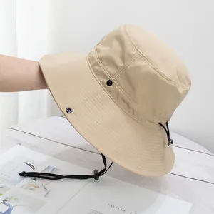 Detail of khaki sun hat featuring breathable metal vents and adjustable black chin strap