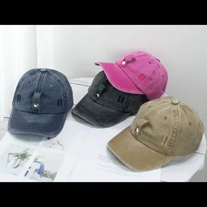 Vue détaillée des casquettes de baseball en coton lavé en bleu marine, gris et rose