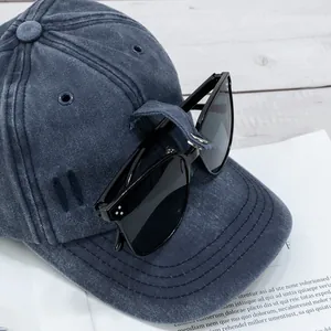 Détail de casquette en denim délavé avec crochets latéraux et lunettes aviateur intégrées