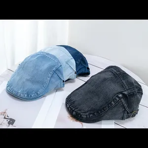 Retro denim flat caps in four colors with adjustable side buckles on a wooden surface