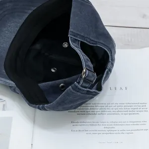 Détail de la casquette en denim gris avec boucle en métal et œillets respirants