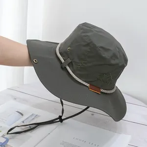 Close-up of deep grey-green sun hat with traveller's embroidery and adjustable wind rope