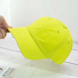 Detailed close-up of neon green baseball cap showing breathable fabric and stitching