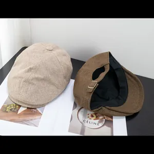 Dettaglio di berretti newsboy in cotone con fibbie metalliche regolabili e fodera interna
