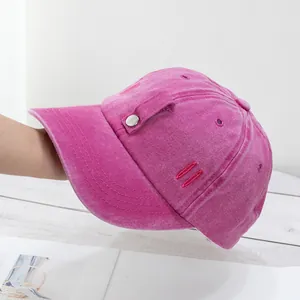 Détail d'une casquette en coton rose délavé avec rivets métalliques et texture vintage usée