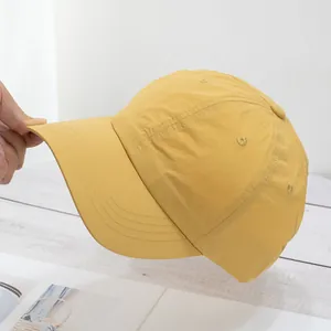 Detail of yellow baseball cap showing soft quick-dry fabric and flexible curved brim