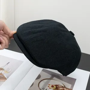 Dettaglio del berretto newsboy in cotone nero che mostra la trama e la tesa rigida