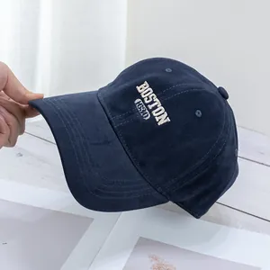Detailed shot of white BOSTON 1830 embroidery on a navy blue cotton baseball cap