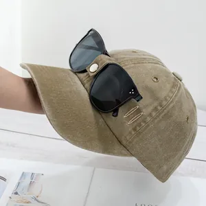 Détail des lanières en cuir fixant les lunettes de soleil sur une casquette kaki