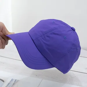 Close-up of purple quick-dry baseball cap with fine fabric texture and decorative stitching