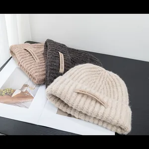 Detailed knit texture of wool blend beanies in khaki, grey and cream with logo labels