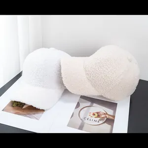 Texture dettagliata di cappellini da baseball in sherpa bianco e beige su sfondo minimalista