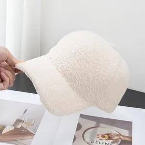 Dettaglio del cappellino beige in lana d'agnello con morbido pile e visiera curva