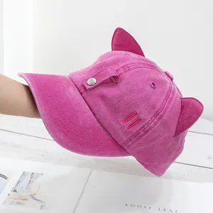 Détail d'une casquette en coton rose délavé avec un design mignon d'oreilles de chat
