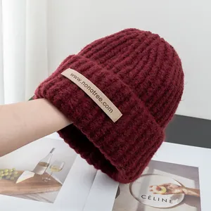 Close-up of dark red ribbed knit hat with high-quality wool blend texture and brand label