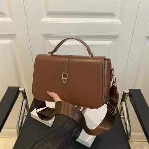 Bruine kleine crossbody tas van zacht leer met brede nylon band en gouden gesp