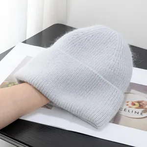Dettaglio del berretto in maglia azzurra in angora con texture soffice e trama a coste