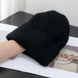 Dettaglio berretto in maglia nera pelosa con texture soffice e bordo risvoltato morbido