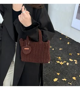Detail der dunkelbraunen Häkeltasche mit handgemachtem Herzanhänger und Textur