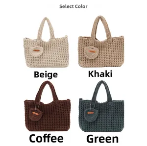Detailgitter der handgefertigten Stricktaschen mit Herzanhängern in vier Erdtönen
