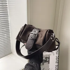Retro dark brown crossbody bag with large buckle detail and wide shoulder strap