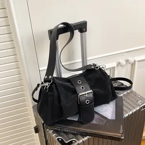 Modern black nylon shoulder bag with large buckle detail on silver textured suitcase